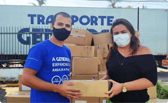 Pessoas segurando uma caixa em frente ao caminhão